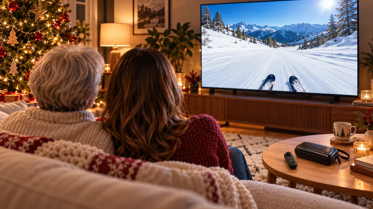 Two adults seen from behind watching their ski footage together.
